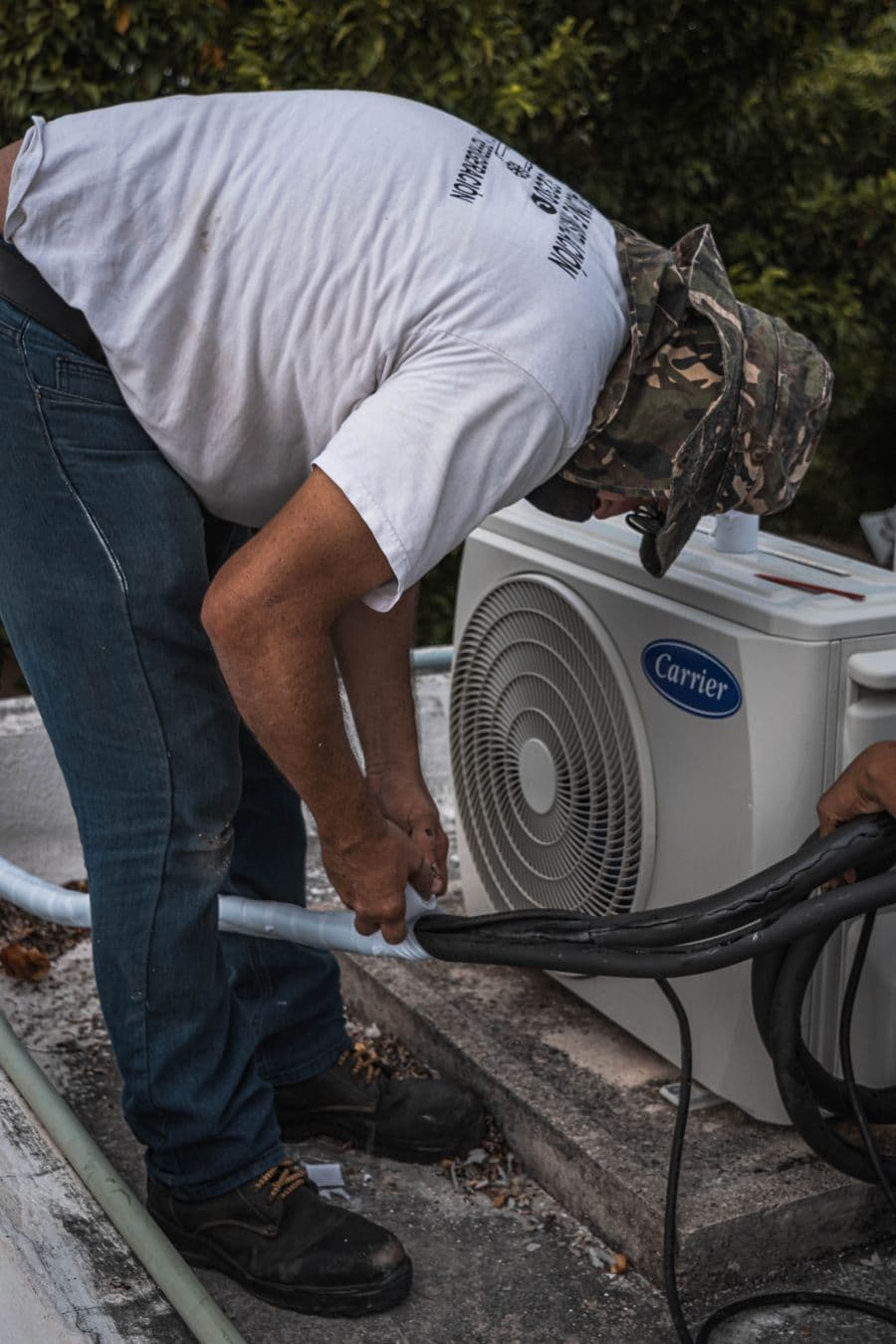 Technician servicing AC refrigerant lines